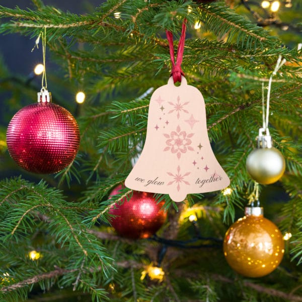 wooden-ornament wood-bell hanging on tree we glow together cinderella